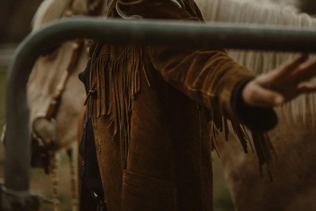 Close detail of fringe suede sleeve holding a leather rein