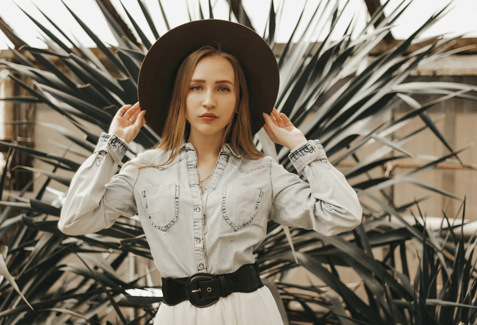 White pearl snap western shirt with a black belt and felt hat