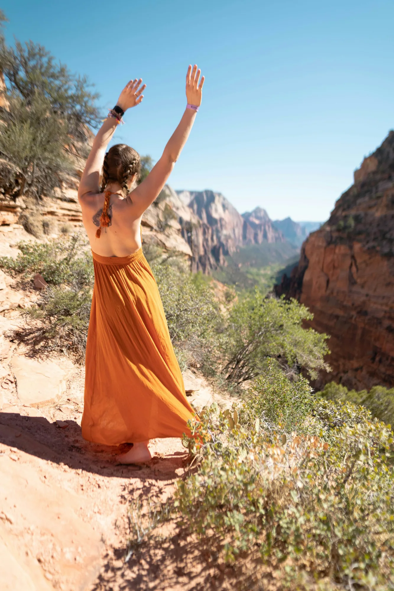 Flowing terracotta maxi dress in a canyon at golden hour