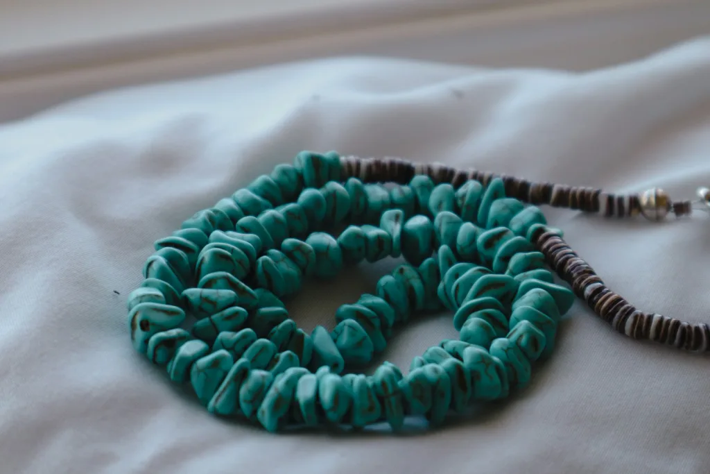 Chunky turquoise necklace with heishi strand on linen