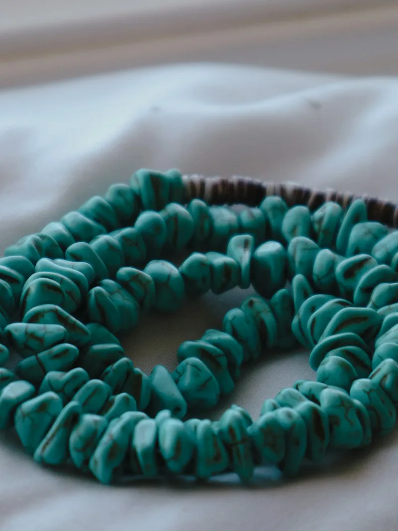 Chunky turquoise necklace with heishi strand on linen